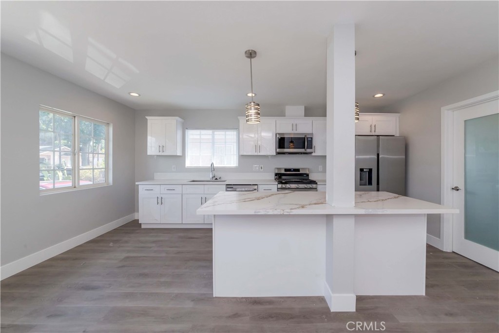 4569 Whitney Drive El Monte, CA 91731 - Photo 19 of 41 a kitchen with kitchen island white cabinets and refrigerator
