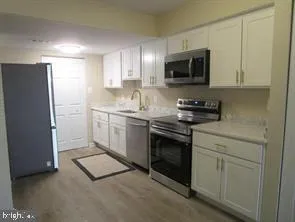 a kitchen with stainless steel appliances a stove a sink and a refrigerator