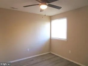 an empty room with a window and a fan