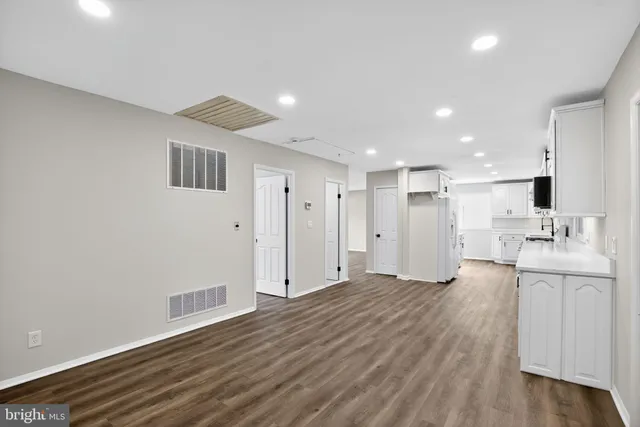 a view of kitchen with refrigerator stove and wooden floor