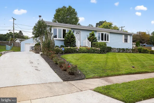 a view of a house with a yard and potted plants