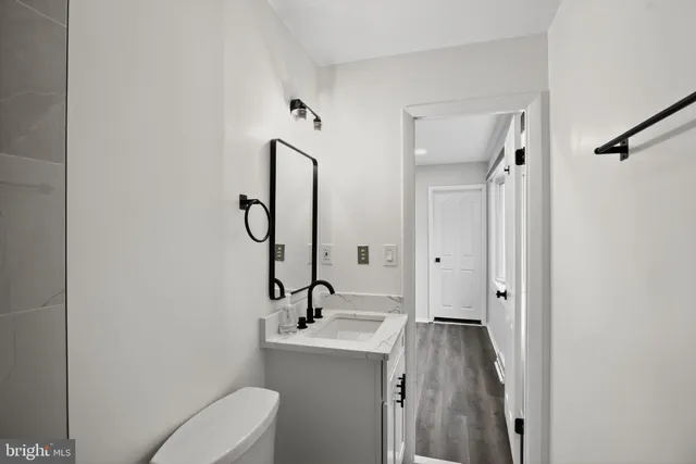 a view of bathroom with a sink mirror and toilet