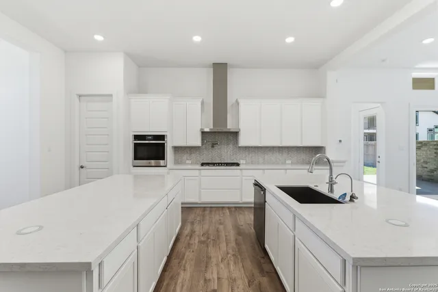 a kitchen with a sink a counter top space stainless steel appliances and cabinets