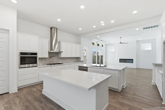 a large kitchen with kitchen island a sink stainless steel appliances and cabinets