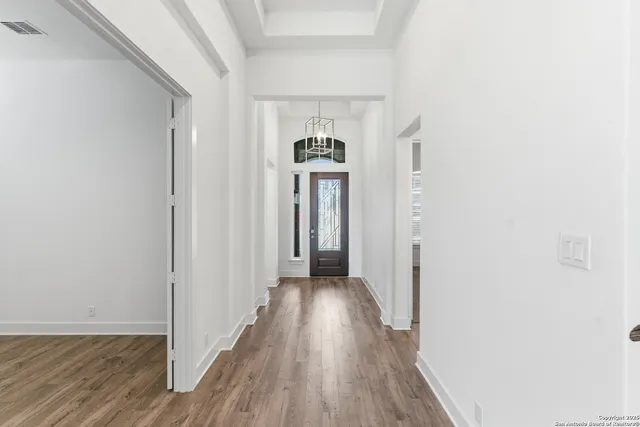 a view of a hallway with wooden floor and staircase