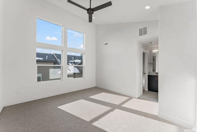 545 East 7215 South Midvale, UT 84047 - Photo 15 of 27 Empty room with a ceiling fan, lofted ceiling, light carpet, and recessed lighting