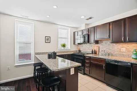 a kitchen with a table chairs sink and cabinets