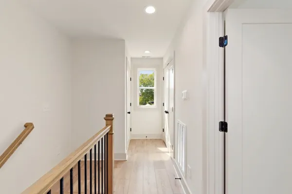 a view of a hallway with wooden floor and closet