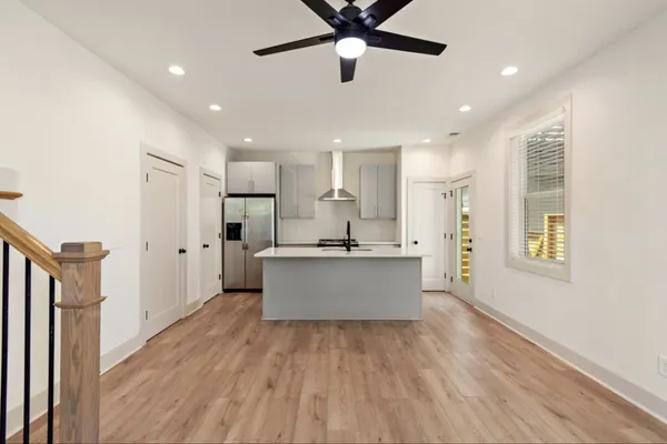 a large room with kitchen island wooden floor and window