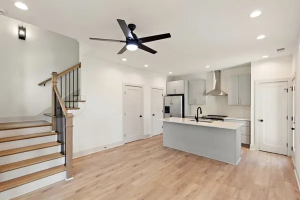 a kitchen with stainless steel appliances a stove top oven a sink and a refrigerator