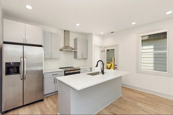 a kitchen with stainless steel appliances a sink a stove a refrigerator and cabinets