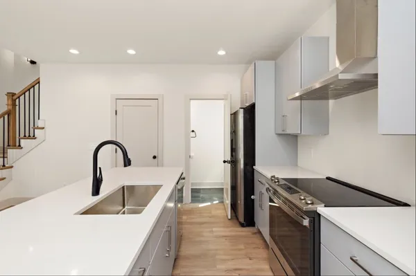 a kitchen with a sink a refrigerator and a stove top oven