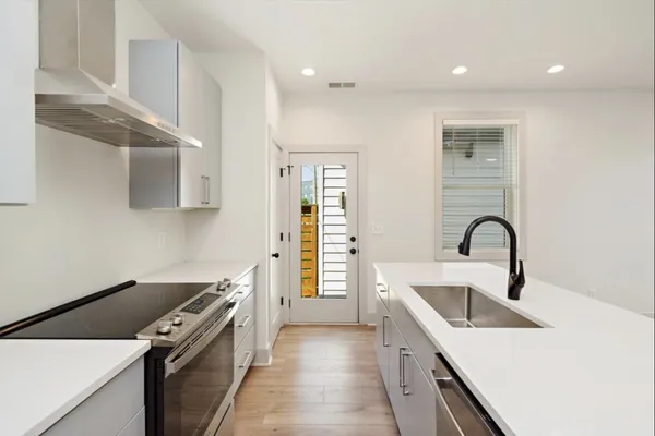 a kitchen with a sink and a stove top oven