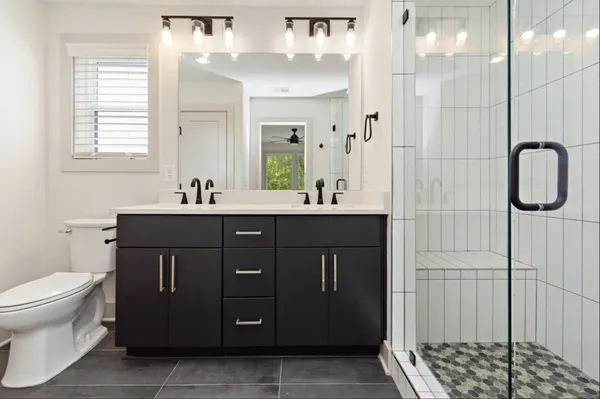a bathroom with a double vanity sink a toilet and a mirror