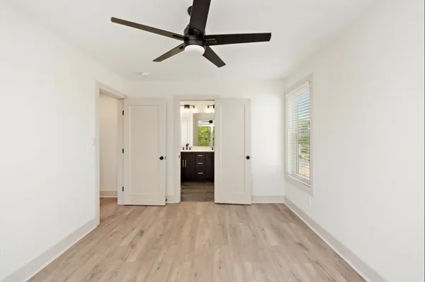 a view of a livingroom with wooden floor and a ceiling fan