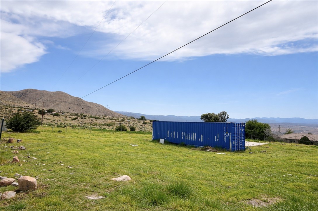 a yard with lots of green space and mountain view in back