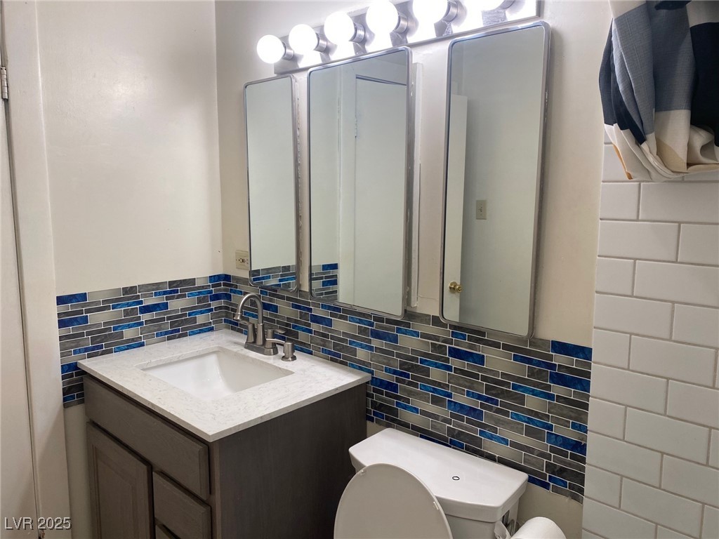 1001 Mill Street Ely, NV 89301 - Photo 12 of 18 Half bath featuring tile walls, backsplash, and vanity