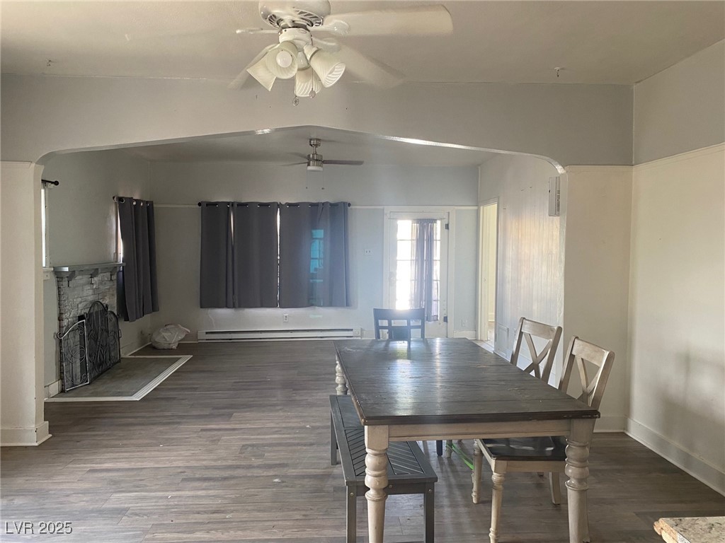 1001 Mill Street Ely, NV 89301 - Photo 2 of 18 Dining area with wood finished floors, a ceiling fan, a fireplace, and arched walkways