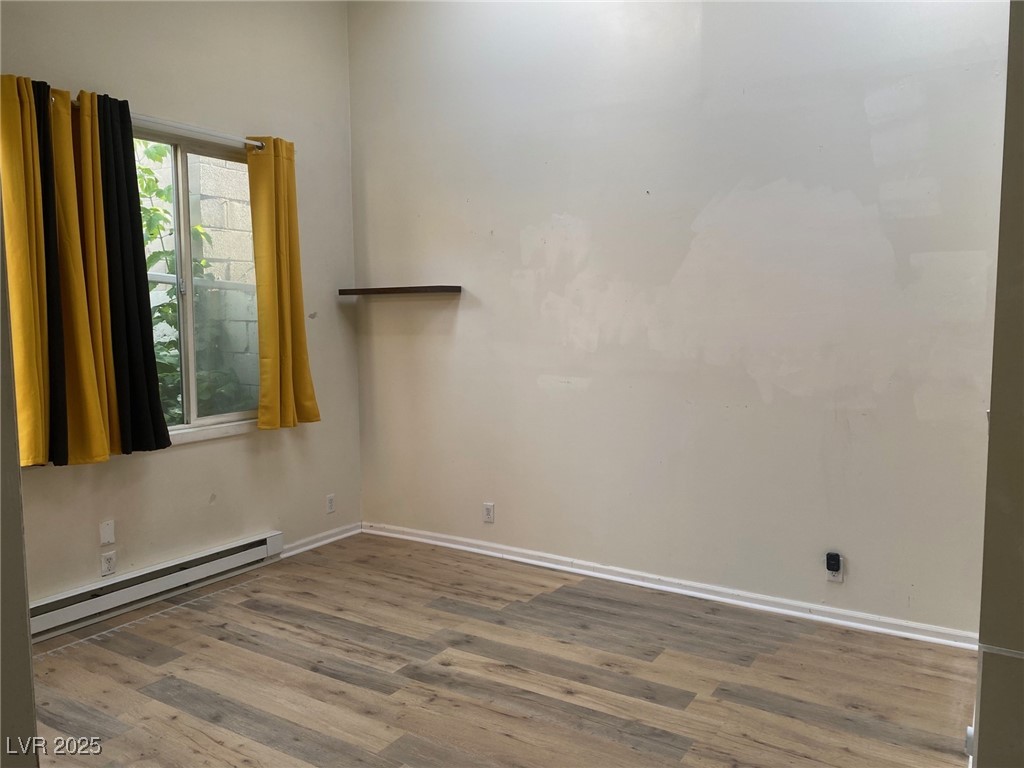 1001 Mill Street Ely, NV 89301 - Photo 8 of 18 Unfurnished room with a baseboard heating unit and wood finished floors
