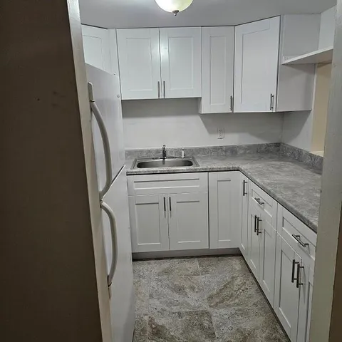 a kitchen with white cabinets and white appliances