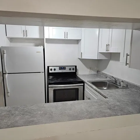 a kitchen with a refrigerator stove and sink
