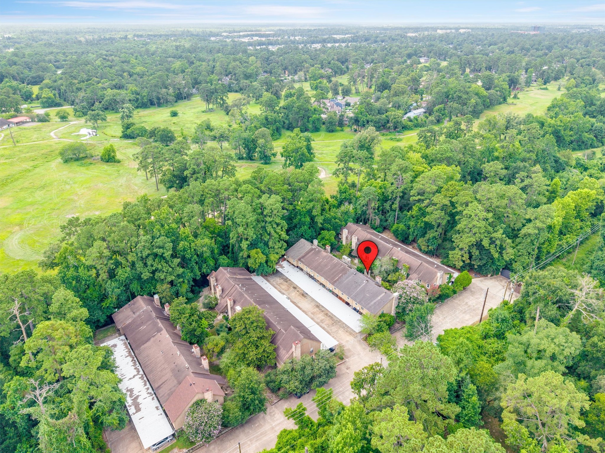 1011 Hamblen Road, Unit 306 Houston, TX 77339 - Photo 34 of 38 The full scope of the community comes into focus here, tree-lined streets, covered parking, and a setting that feels more like a retreat than a typical townhome row.