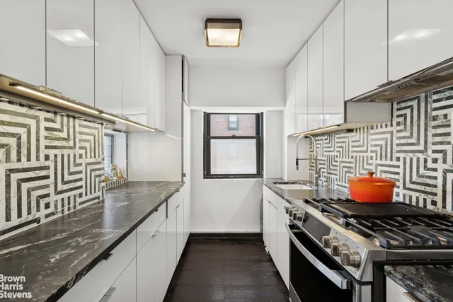 a kitchen with stainless steel appliances granite countertop a stove a sink and a refrigerator