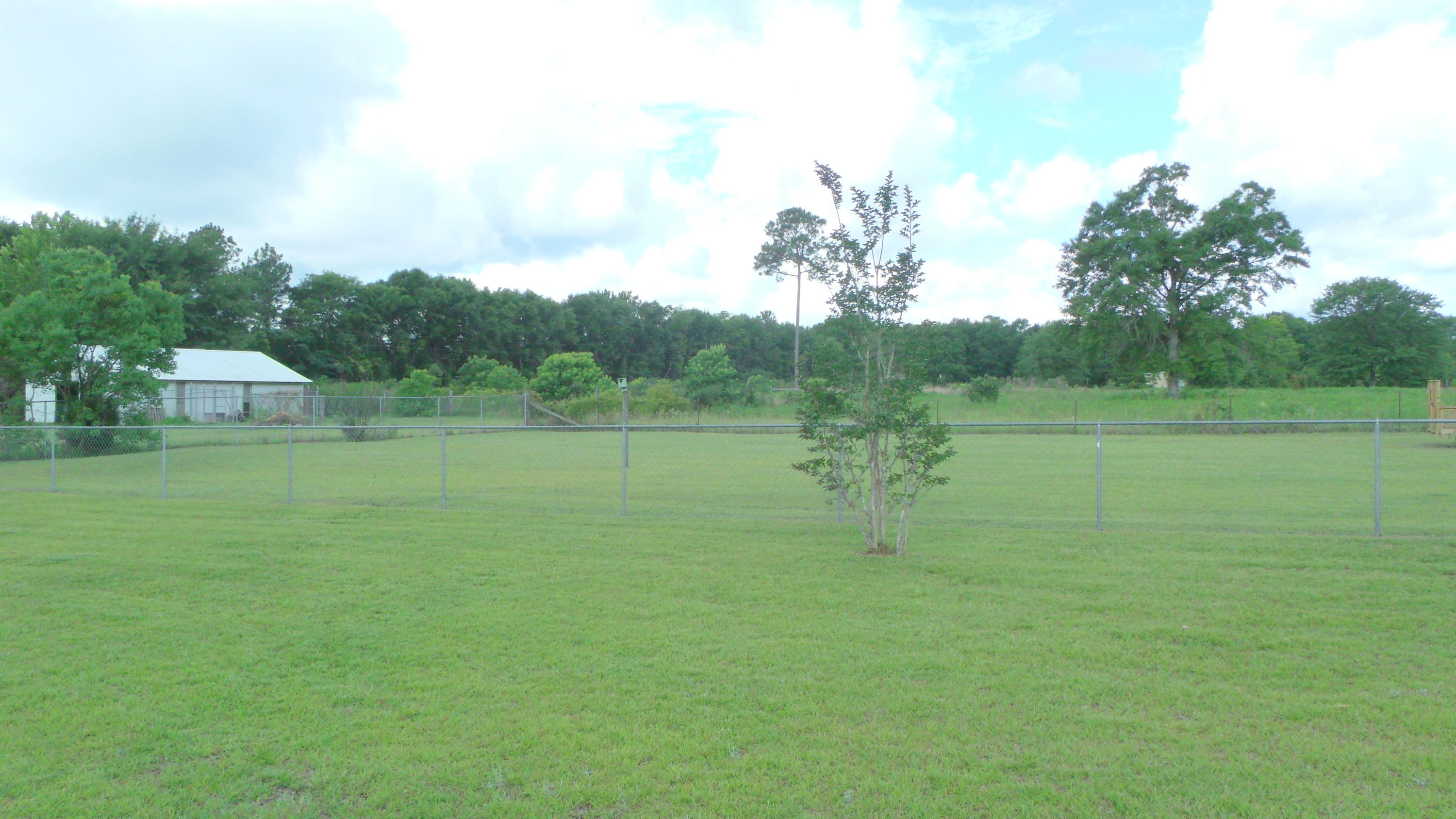 5918 Jack Stokes Road Baker, FL 32531 - Photo 7 of 23 a view of a green field with wooden fence