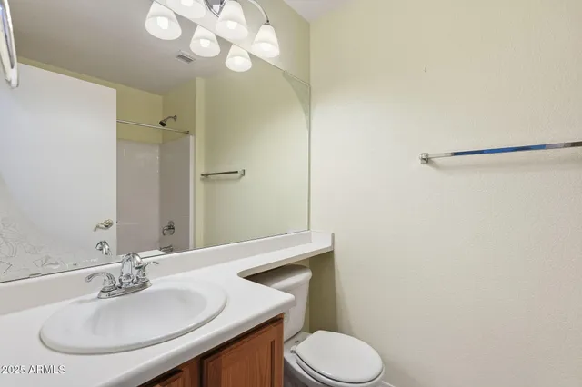 a bathroom with a sink a toilet and a mirror