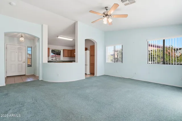 an empty room with fan and windows