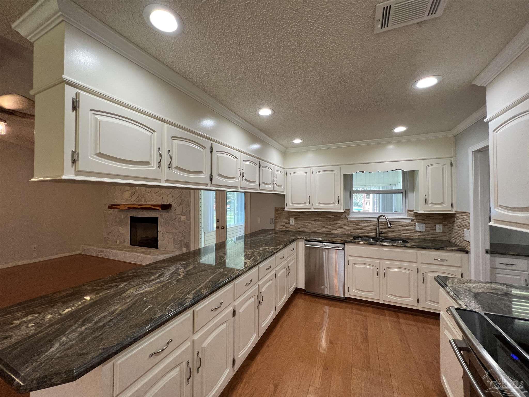 3143 Aarons Way Pace, FL 32571 - Photo 13 of 38 a large kitchen with stainless steel appliances granite countertop a sink and cabinets