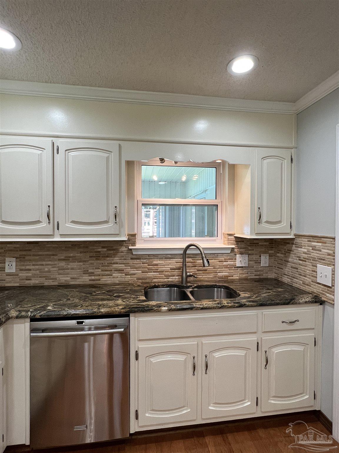 3143 Aarons Way Pace, FL 32571 - Photo 16 of 38 a kitchen with granite countertop white cabinets and a sink