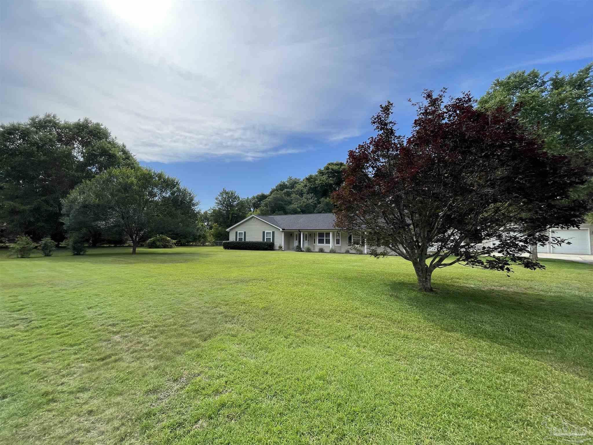 3143 Aarons Way Pace, FL 32571 - Photo 2 of 38 a front view of a house with a garden