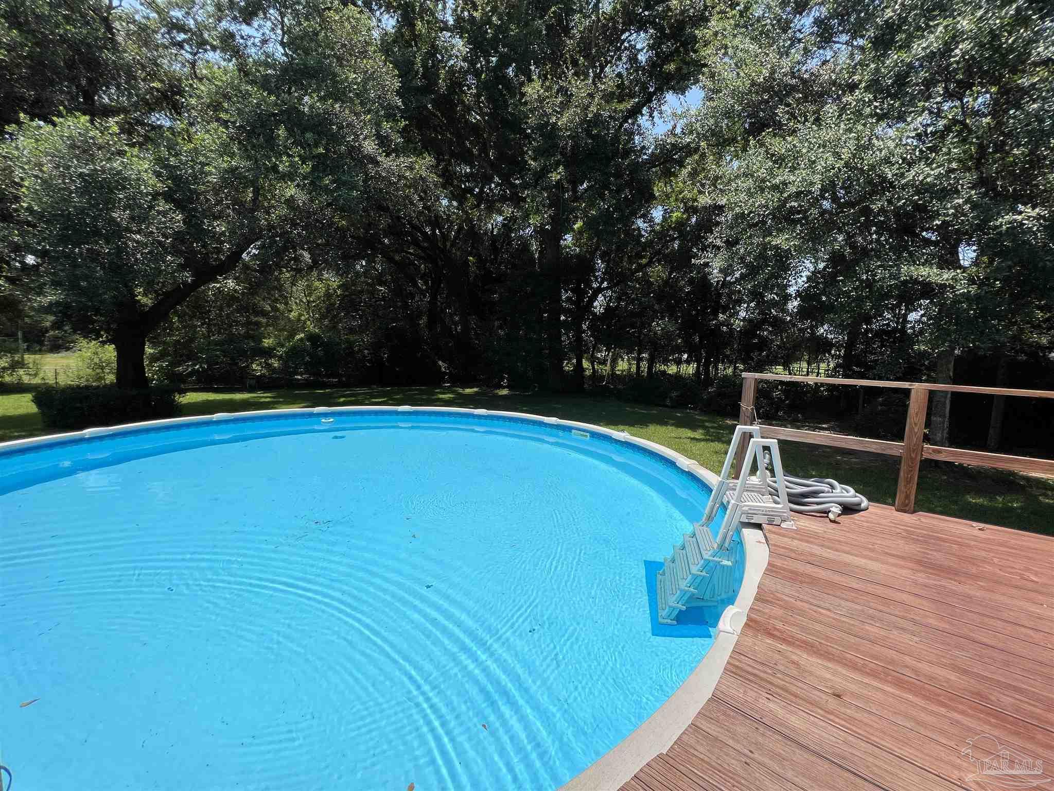 3143 Aarons Way Pace, FL 32571 - Photo 37 of 38 a view of a swimming pool with a patio and yard