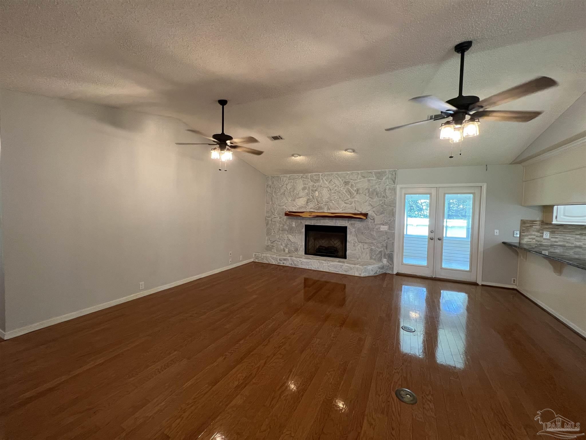 3143 Aarons Way Pace, FL 32571 - Photo 8 of 38 a view of an empty room with wooden floor fireplace and a window
