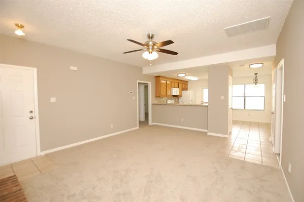 an empty room with fan and windows