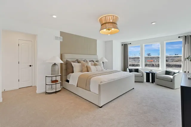 a spacious bedroom with a bed and a large window