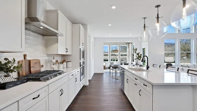 a large white kitchen with cabinets and a stove