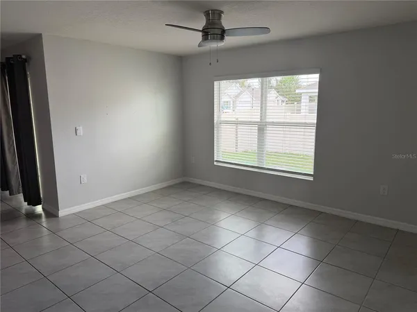 an empty room with windows and fan