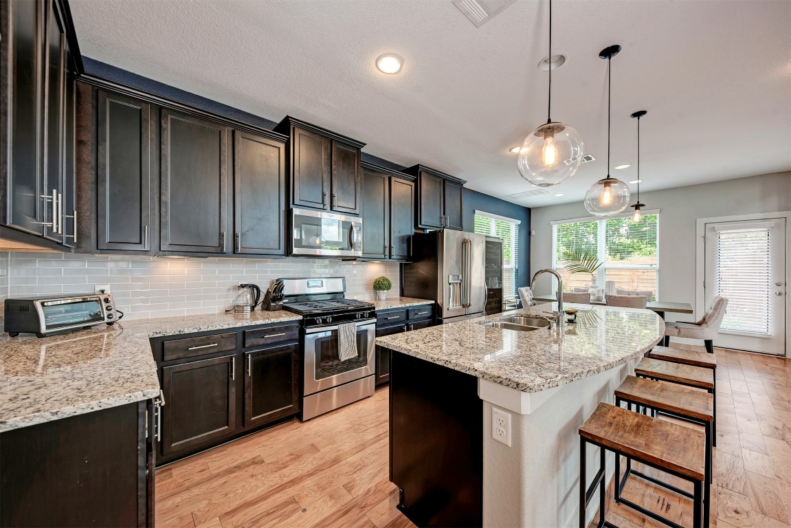 6006 Rubicon Run Austin, TX 78745 - Photo 8 of 22 a kitchen with stainless steel appliances granite countertop a sink stove and refrigerator