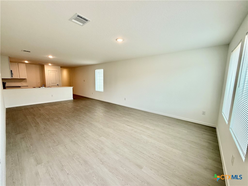 413 Moscato Road New Braunfels, TX 78130 - Photo 11 of 28 an empty room with wooden floor and windows