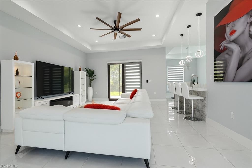 2330 4th Avenue Southeast Naples, FL 34117 - Photo 12 of 39 Living area featuring light tile patterned floors, a raised ceiling, recessed lighting, and ceiling fan
