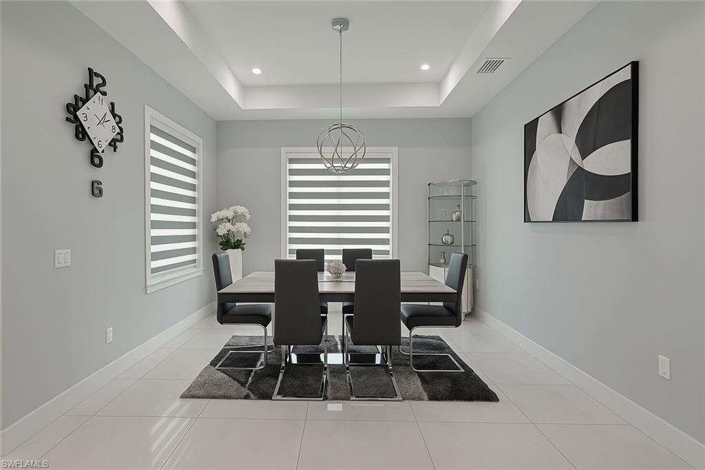 2330 4th Avenue Southeast Naples, FL 34117 - Photo 18 of 39 Dining area with light tile patterned floors, a chandelier, a tray ceiling, and recessed lighting