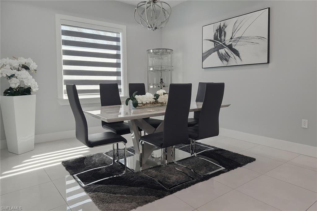 2330 4th Avenue Southeast Naples, FL 34117 - Photo 19 of 39 Dining room with light tile patterned flooring and a chandelier