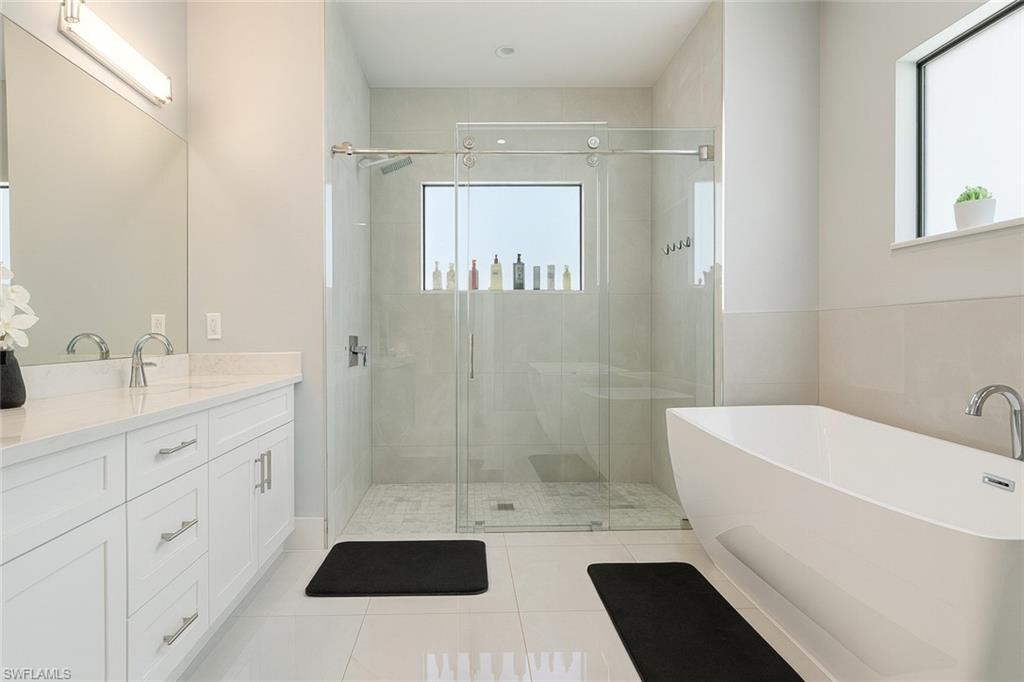 2330 4th Avenue Southeast Naples, FL 34117 - Photo 25 of 39 Full bath with a freestanding tub, light tile patterned floors, a shower stall, and plenty of natural light