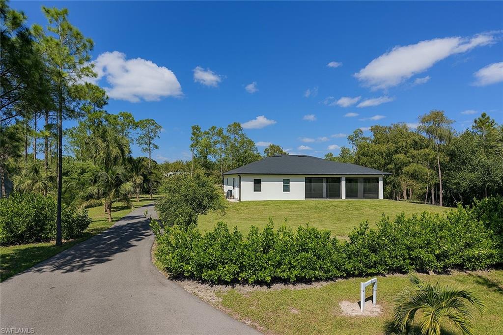 2330 4th Avenue Southeast Naples, FL 34117 - Photo 8 of 39 Back of property with a lawn and a sunroom