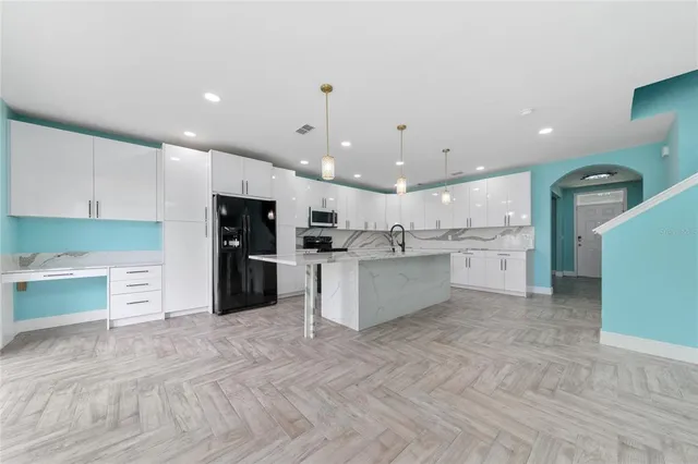 a large kitchen with stainless steel appliances kitchen island a large counter top and a sink