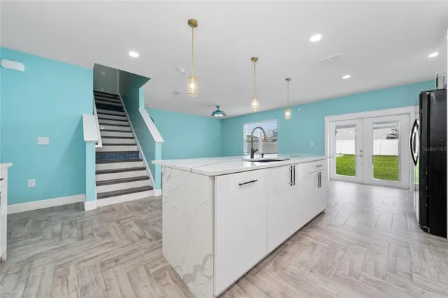a large white kitchen with a large island oven a sink and dishwasher