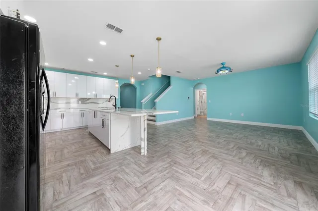 a view of kitchen with stainless steel appliances cabinets and refrigerator