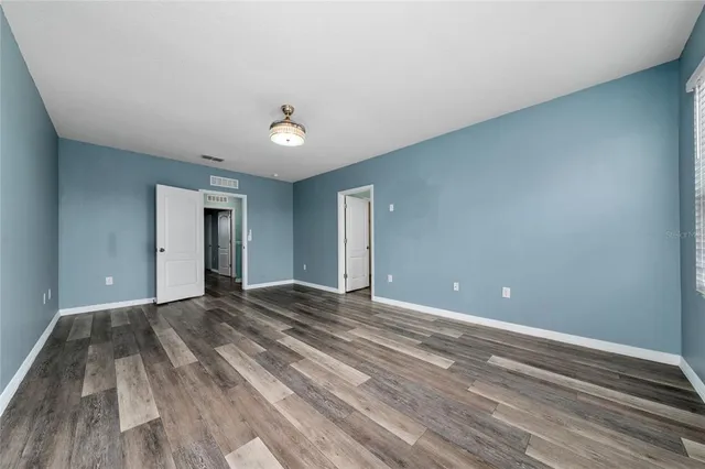 a view of an empty room with wooden floor